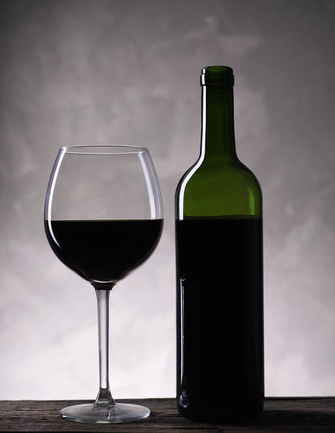 Red wine bottle and wine glass - Фото, изображение