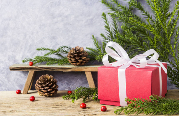 Décoration de Noël de boîte cadeau rouge avec ruban blanc et cône de pin sur vieux bois
 - Photo, image