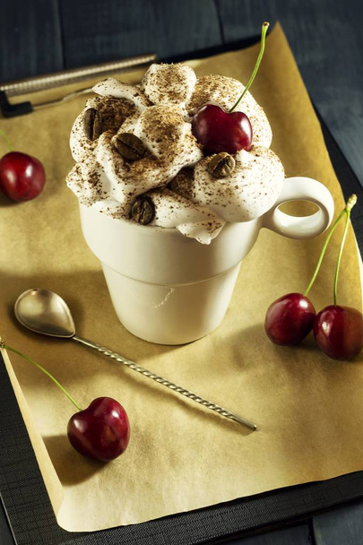 Schokoladenkuchen mit Kirschen und eine Tasse Kaffee mit Schlagsahne. Kaffeepause. - Foto, Bild