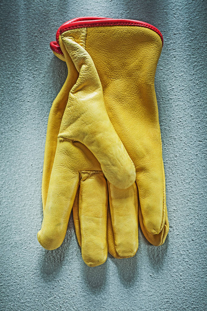 Leather safety gloves on concrete background vertical view const - Φωτογραφία, εικόνα