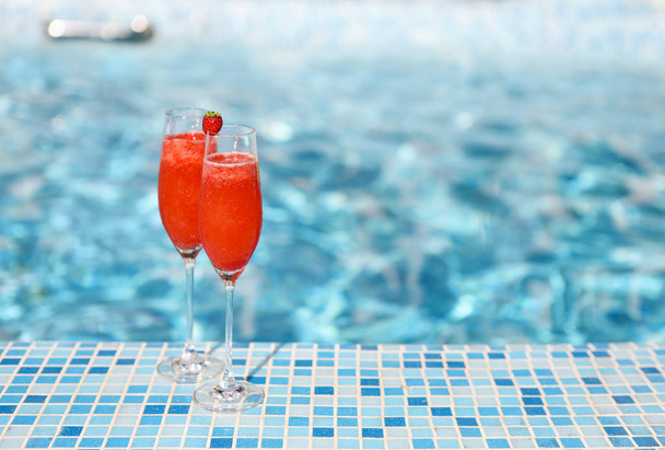 Champagne glasses with strawberry. Rossini cocktail. Summer pool - Фото, зображення