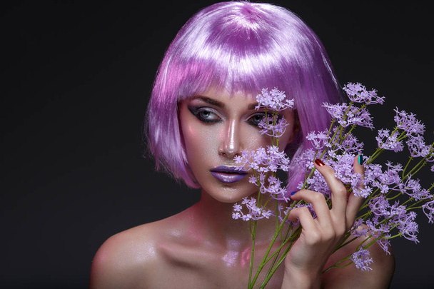 Menina bonita em peruca roxa com flores
 - Foto, Imagem
