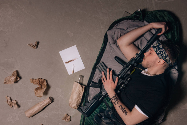 Soldat schläft mit Gewehr. schlechte Gewohnheiten. - Foto, Bild