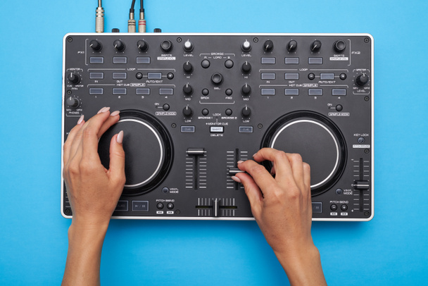Mani femminili che suonano DJ mixer su sfondo blu
 - Foto, immagini