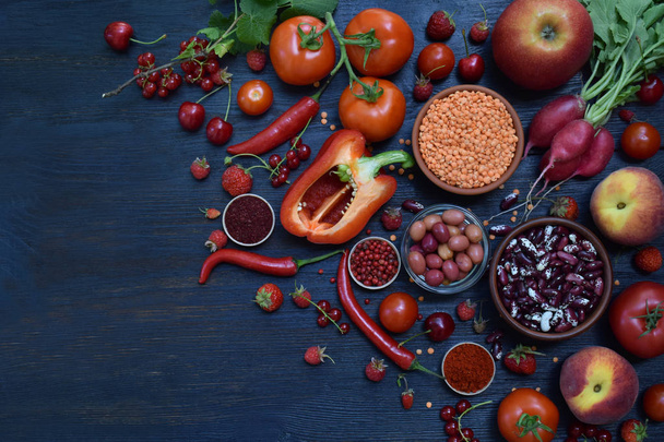 punaisten kasvistuotteiden koostumus: hedelmät, vihannekset, mausteet ja pavut puupohjalla. Omenatomaatteja, herukkapaprikaa, vadelmakirsikkaa, linssejä. Terveellistä ruokaa. Kopioi tilaa tekstille
 - Valokuva, kuva