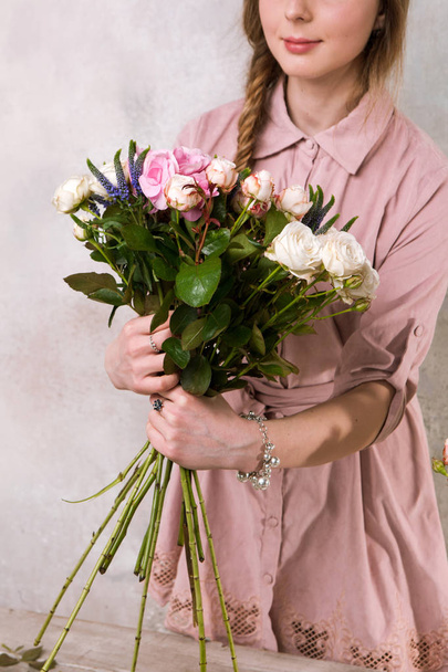 Florist makes a bouquet of rose flowers. - Foto, imagen