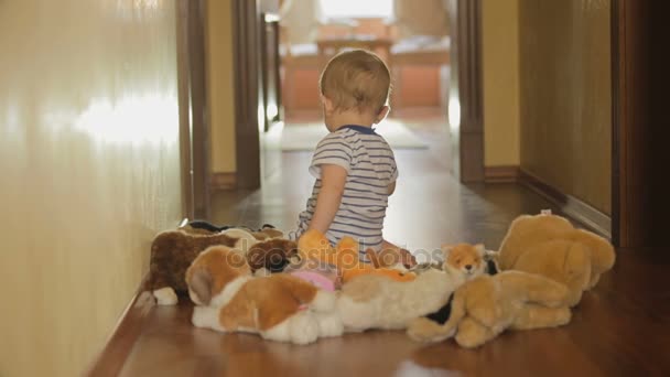 niedlicher kleiner Junge spielt zu Hause mit Plüschtierspielzeug auf dem Boden - Filmmaterial, Video