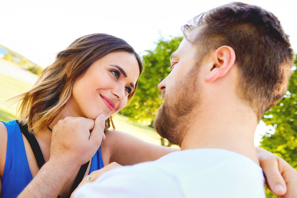 Young man stroking face of his happy girlfriend - Foto, Bild
