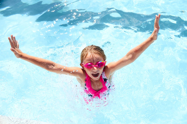 glückliches kleines Mädchen, das Spaß im Schwimmbad hat - Foto, Bild