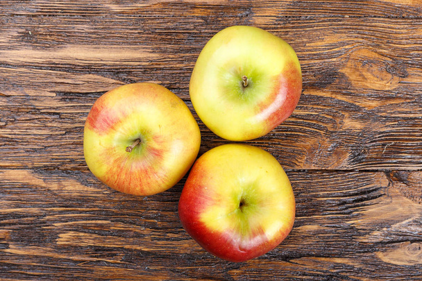 ahşap bir masa, yaz hasat, sağlıklı olarak olgun elma yeme. - Fotoğraf, Görsel