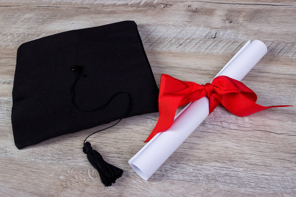 Graduiertenmütze, Hut mit Diplomarbeit auf Holztisch Graduierungskonzept - Foto, Bild