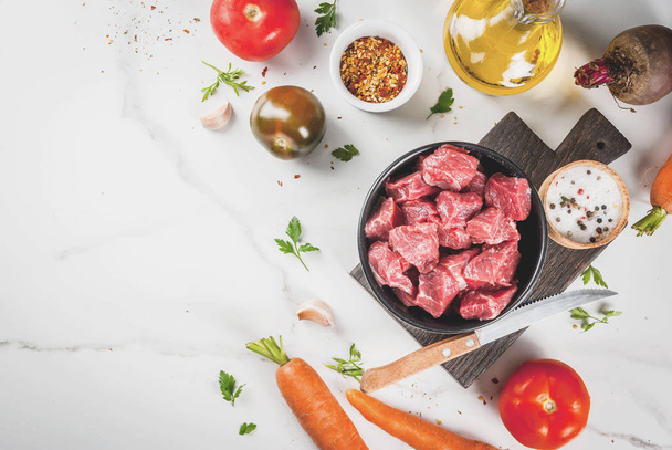 Meat, beef. Fresh raw chopped goulash, beef cubes in a bowl. Spi - Fotó, kép