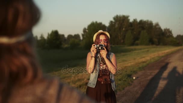 Hipster-Mädchen beim Fotografieren seiner Freundin mit einer Filmkamera. Zwei junge Frauen werden im Morgengrauen fotografiert. Zeitlupe - Filmmaterial, Video