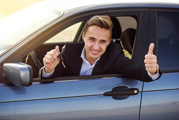 comprador feliz segurando chaves do carro dentro de seu novo veículo
 - Foto, Imagem