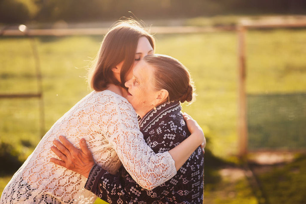 Young woman hugging a grandmother outdoors. - Foto, Imagem