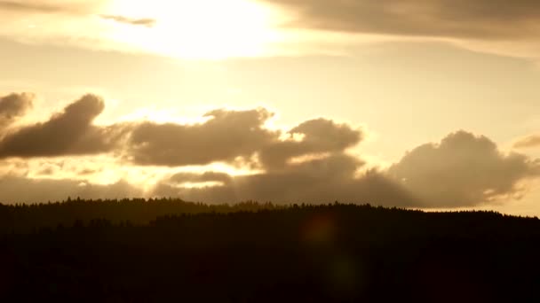 Ηλιοβασίλεμα στα σύννεφα και πάνω από τις κορυφές έλατα. Πάροδο του χρόνου - Πλάνα, βίντεο