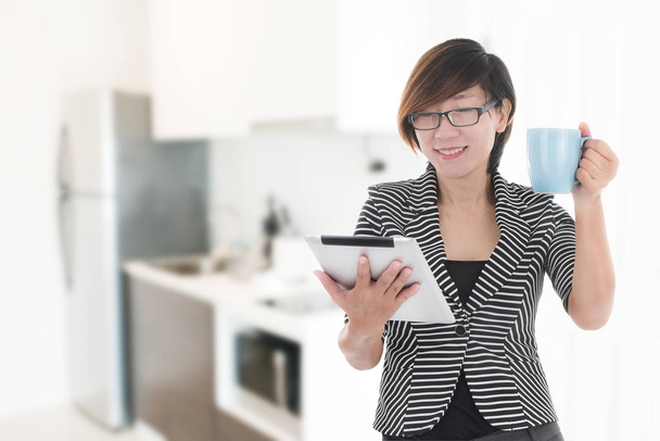Modern businesswoman using tablet and drinks coffee with Blurry  - 写真・画像