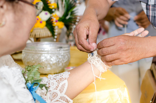 Man make ceremonial thread to grandmother and praying for long l - Фото, изображение