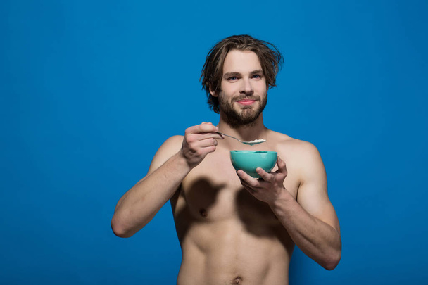 healthy food and dieting, man with bare chest eating oatmeal - Foto, Imagen