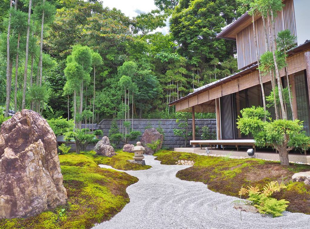 Grind pad, stenen lantaarn, stenen en houten gebouw in Japanse tuin - Foto, afbeelding