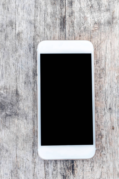 Imagem de vista superior do smartphone sobre sala de mesa de madeira para texto, pronto para mockup. Espaço vazio.
. - Foto, Imagem