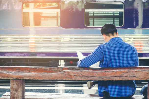 Traveler man with map and waits train on railway platform - Valokuva, kuva