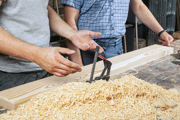 dva muži ukazují, jak zpracovat dřevěném prkénku - Fotografie, Obrázek