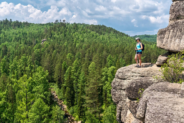 The girl is standing on top of a cliff - Foto, Bild