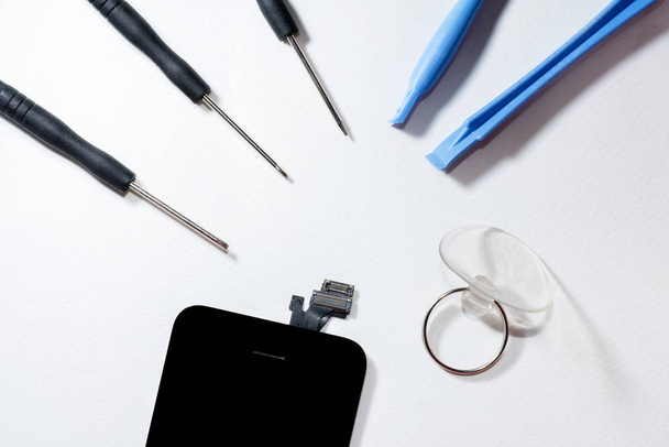 Інструменти для ремонту смартфона, який стоїть ізольовано на білому тлі. (інструменти
) - Фото, зображення