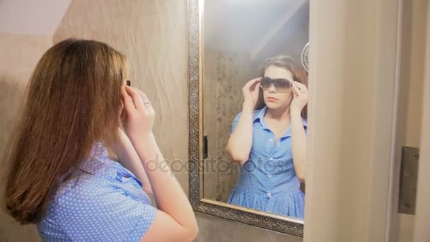 4 k felvételeket a gyönyörű fiatal nő, tükör napszemüveg kiválasztása - Felvétel, videó