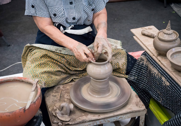 Manos de alfarero sénior moldeando olla de arcilla tradicional
 - Foto, Imagen