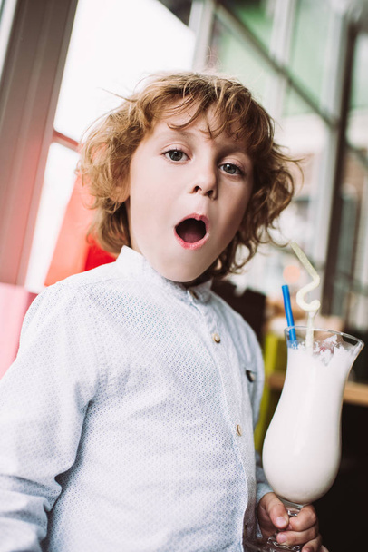 маленький мальчик держит молочный коктейль
 - Фото, изображение