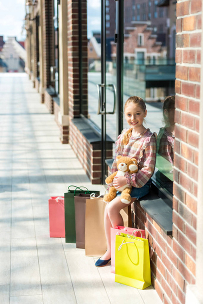 girl with shopping bags holding teddy bear - Fotoğraf, Görsel