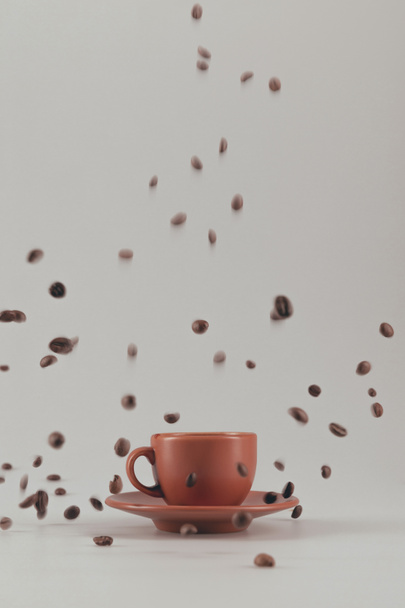 taza de café con granos de café que caen
 - Foto, Imagen