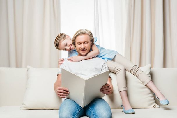 father and daughter reading book - Valokuva, kuva