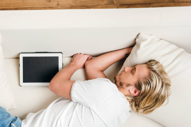 muž spí na pohovce s digitálním tabletu   - Fotografie, Obrázek