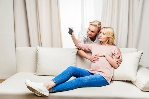 Pregnant couple using smartphone  - Photo, image