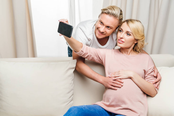 Pregnant couple using smartphone  - Photo, Image