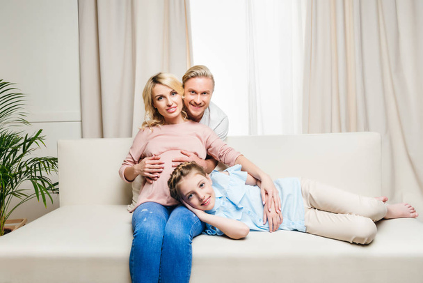 family sitting on sofa at home - Foto, imagen