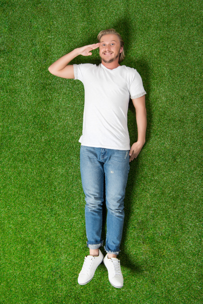 muž ležící gestem pozdravu na louce - Fotografie, Obrázek