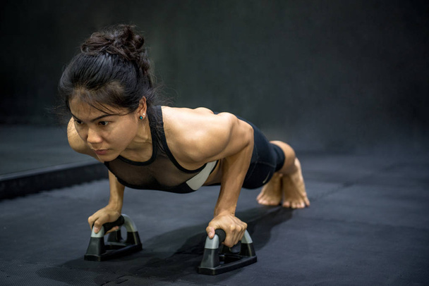 Νεαρός αθλητής ασιατική γυναίκα κάνει ώθησης στο πάτωμα - Φωτογραφία, εικόνα