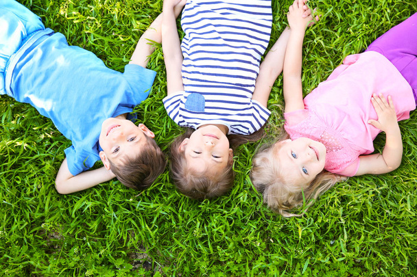dzieci leżąc na trawie  - Zdjęcie, obraz