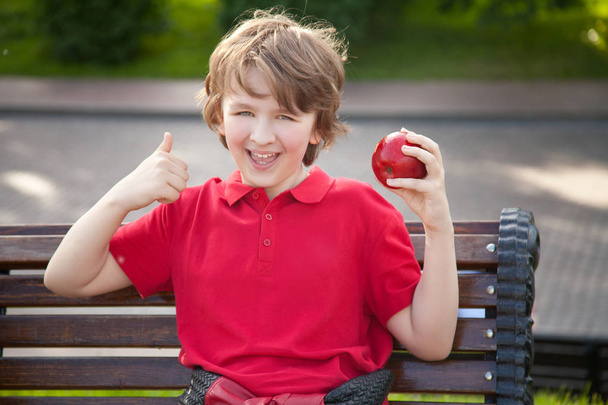 niño alegre con gran manzana roja al aire libre divertirse
 - Foto, Imagen