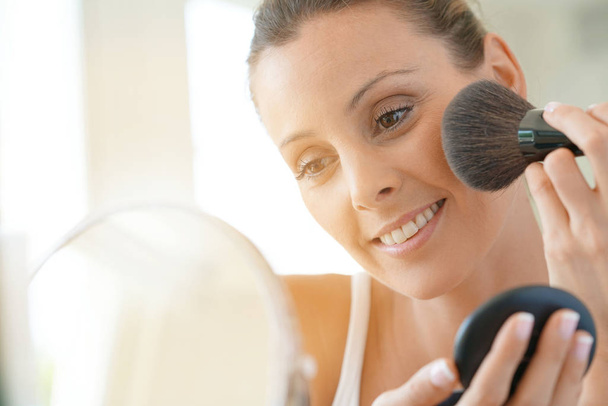 woman putting makeup on - 写真・画像