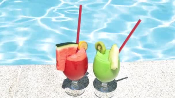 Cocktails op de achtergrond van het zwembad. Twee fruit cocktails. Zomer- en rusttijden. - Video