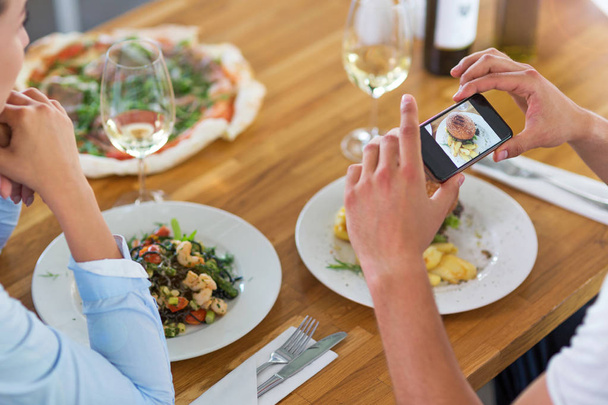 Amis avec smartphone photographier la nourriture au café
 - Photo, image