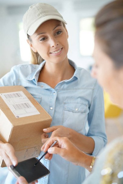 Delivery woman handing package - Fotó, kép