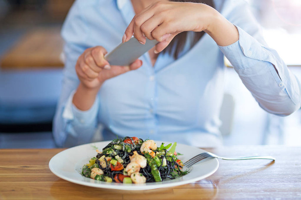 žena s smartphone fotografování jídla v kavárně - Fotografie, Obrázek