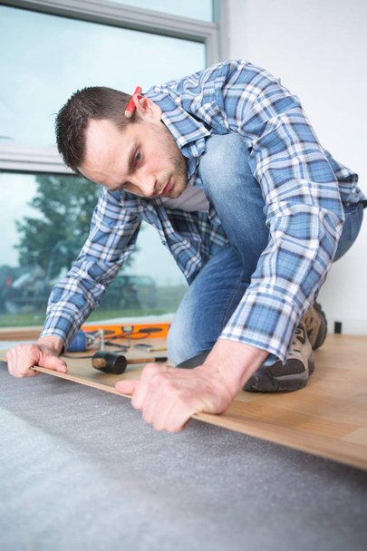 handyman laying down a carpet in a new house - Valokuva, kuva