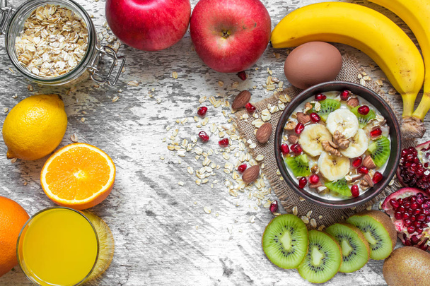 oatmeal porridge with banana, kiwi fruit, pomegranate, cinnamon and nuts - Fotografie, Obrázek